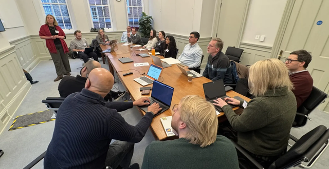 Roundtable of evidence champions with laptops at Pembroke College
